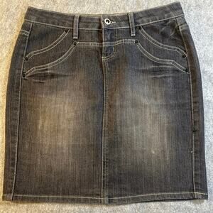 This Cache denim skirt features a black and gray wash with stud details. Size 4